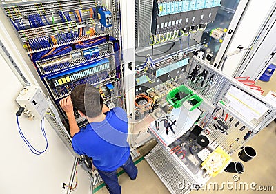 man assembles electronic components on a machine in a factory for mechanical engineering Stock Photo