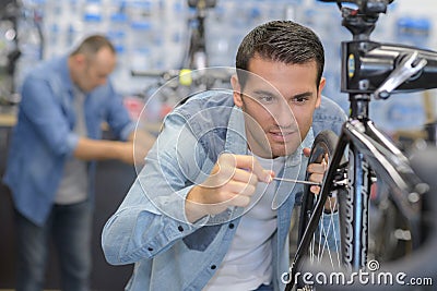 Man assembling bike carefully Stock Photo