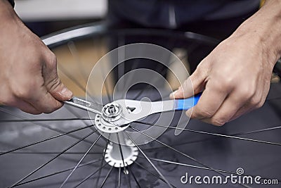 Man assembling a bike wheel axle after the process of cleaning and greasing Stock Photo