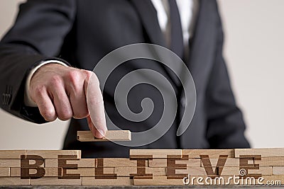 Man assembling word Believe Stock Photo