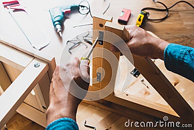 Man assembly wooden furniture,fixing or repairing house with screwdriver tool.modern living concepts Stock Photo