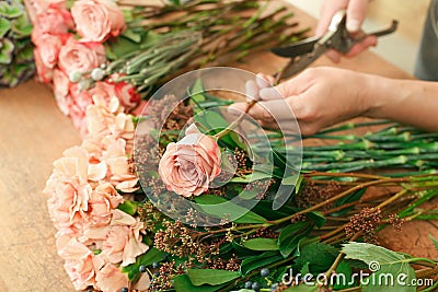 Man assistant in flower shop delivery make rose bouquet closeup Stock Photo