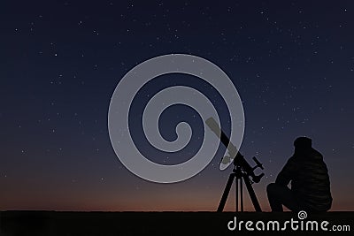 Man with astronomy telescope looking at the stars. Stock Photo