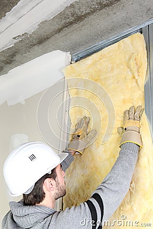 Man attaching insulation to wall Stock Photo