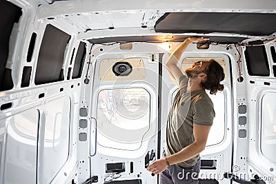 Man attaching thermal insulation in a camper van Stock Photo