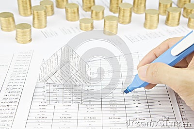 Man is auditing account by highlighter beside house Stock Photo