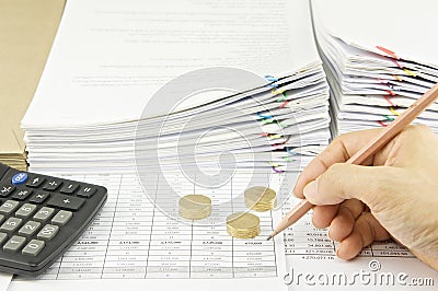Man auditing account by pencil and gold coins with calculator Stock Photo