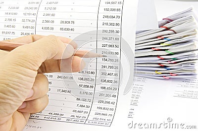 Man auditing account by pencil with pile of paperwork Stock Photo
