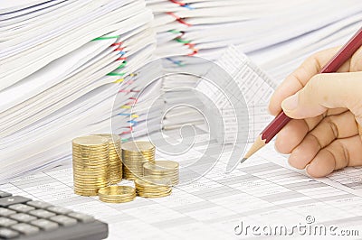 Man is auditing account with pencil and step gold coins Stock Photo
