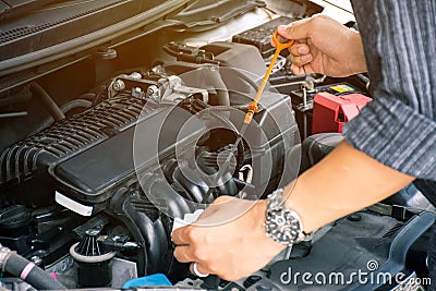 Man or auto mechanic worker hands checking the car engine oil and maintenance. Stock Photo