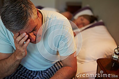 Man Awake In Bed Suffering With Insomnia Stock Photo