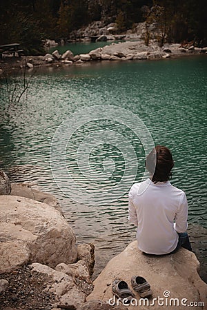 Man on the background of a mountain lake, tranquility and unity with nature in Turkey. authentic Stock Photo