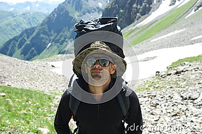 Man with a backpack high in mountains. Travelling background. Healthy lifestyle. Summer outdoor activity. Hiking. Stock Photo