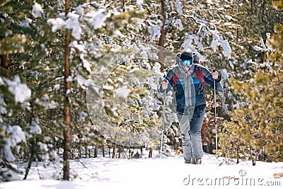 Man with backpack trekking in mountains. Cold weather, snow on Stock Photo