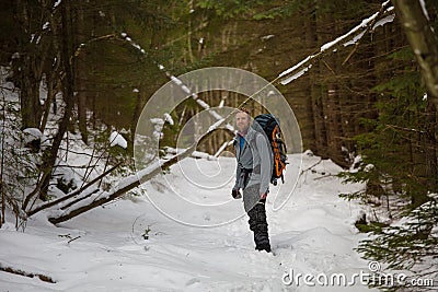 Man is backpacking in winter forest Stock Photo