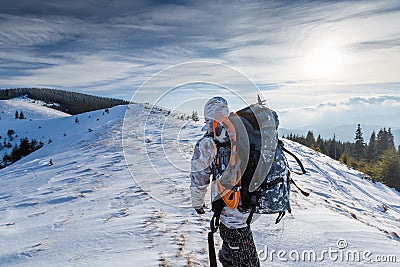 Man is backpacking in winter mountains Stock Photo