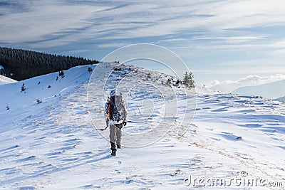 Man is backpacking in winter mountains Stock Photo