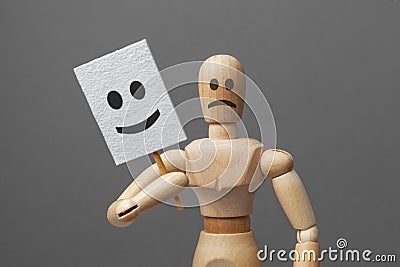 Man with bad evil mood and holds mask of good cheerful mood with smile. hypocrisy. Stock Photo