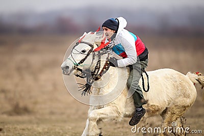 Man is bareback riding an adorned horse before an Epiphany celebration horse race Editorial Stock Photo