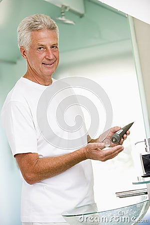Man in bathroom applying aftershave Stock Photo