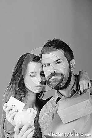 Man with beard holds credit card and piggy bank. Stock Photo