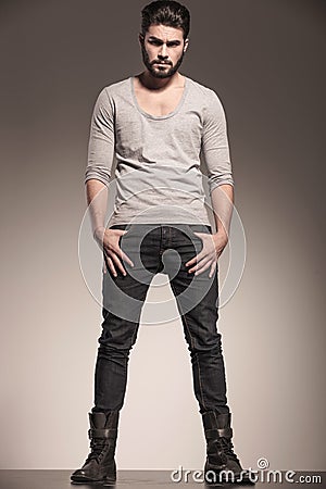 Man with beard standing with hands in pockets Stock Photo