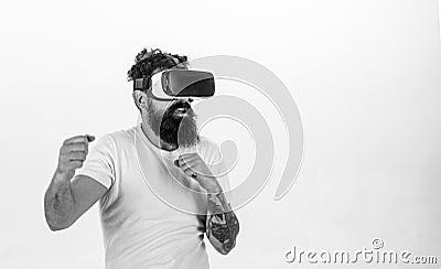 Man with beard in VR glasses fighting, white background. VR gadget concept. Hipster on busy face exploring virtual Stock Photo