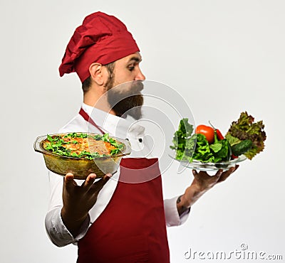 Man with beard, white background. Chef hold bowl with potato Stock Photo