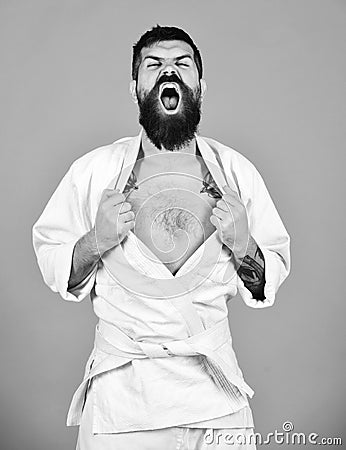 Man with beard in white kimono on red background. Japanese martial arts concept. Karate man with angry face Stock Photo