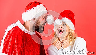 Man with beard and woman santa hat red background. Couple cheerful face celebrate christmas. Rent santa costume. Couple Stock Photo