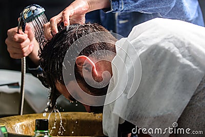 Man bearded client of hipster barbershop. Barbershop concept. Barbers hands washing hair of bearded hipster. Man with Stock Photo