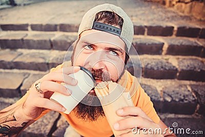 Man bearded eat tasty sausage. Urban lifestyle nutrition. Junk food. Carefree hipster eat junk food while sit stairs Stock Photo