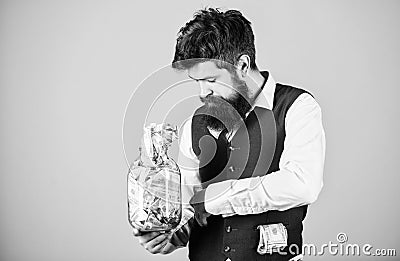 Man bearded guy hold jar full of cash savings. Start saving for your retirement as early as possible. Establish your Stock Photo