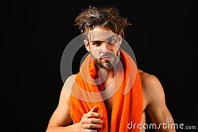 Man bearded tousled hair covered with foam or soap suds. Wash off foam carefully. Man with orange towel on neck ready to Stock Photo