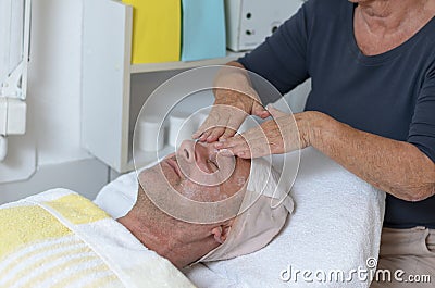 Man at beauty center receiving facial treatment Stock Photo