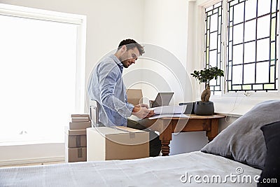 Man In Bedroom Running Business From Home Dispatching Goods Stock Photo