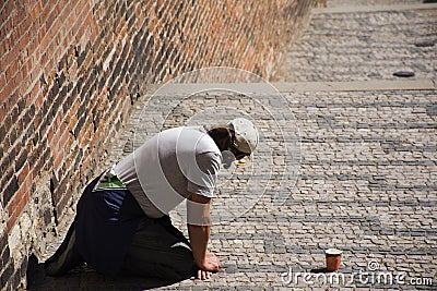 Man beggar kneeling begging money from people Editorial Stock Photo