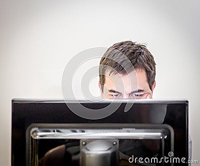 Man behind the monitor of a desk computer Stock Photo