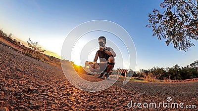 Man with bicycle on little on a park with trees, soft blue sky and sunset. Outdoor dramatic of man with mask in a park and Stock Photo