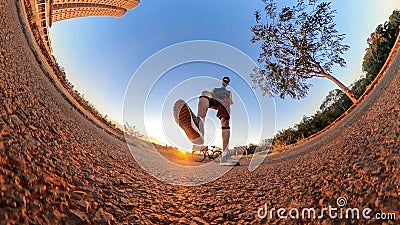 Man with bicycle on little on a park with trees, soft blue sky and sunset. Outdoor dramatic of man with mask in a park and Stock Photo