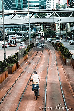 Bicycle riding in the area for double-decker trams in Hong Kong Editorial Stock Photo