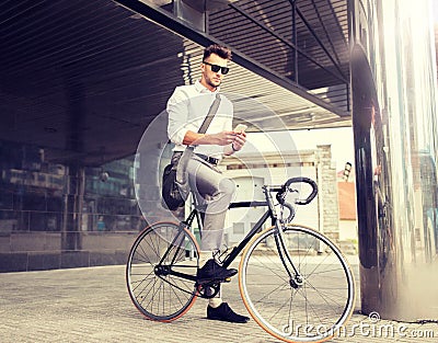 Man with bicycle and smartphone on city street Stock Photo