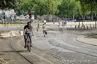 Man on bike by tramway route of Bordeaux. September 2013. France Editorial Stock Photo