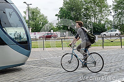 Man on bike by tramway route of Bordeaux. September 2013. France Editorial Stock Photo