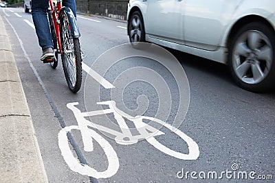 Man On Bike Using Cycle Lane As Traffic Speeds Past Stock Photo