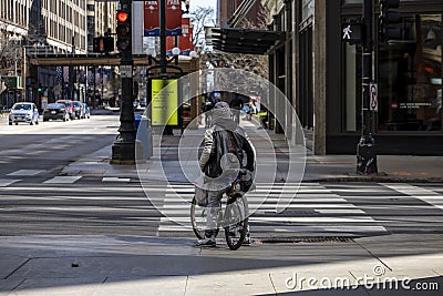 man biking in the empty streets in the downtown Chicago area Editorial Stock Photo