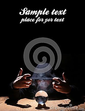 Man in a black hood with cristal ball and empty space for text Stock Photo