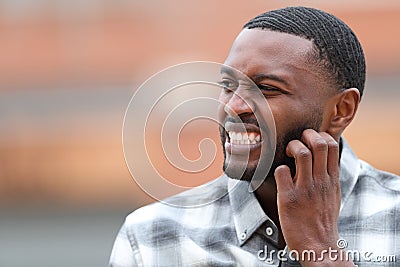 Man with black skin scratching itchy beard Stock Photo