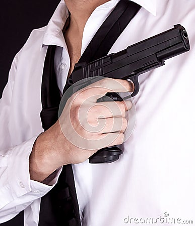 Man in black suit holding gun in hand. Secret agent, mafia, bodyguard concept Stock Photo