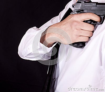 Man in black suit holding gun in hand. Secret agent, mafia, bodyguard concept Stock Photo